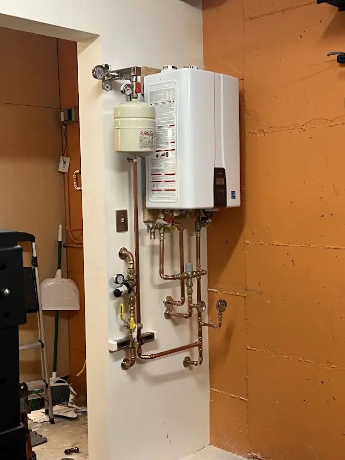 Plumbing technician inspecting water heater connections in Hawthorn Woods